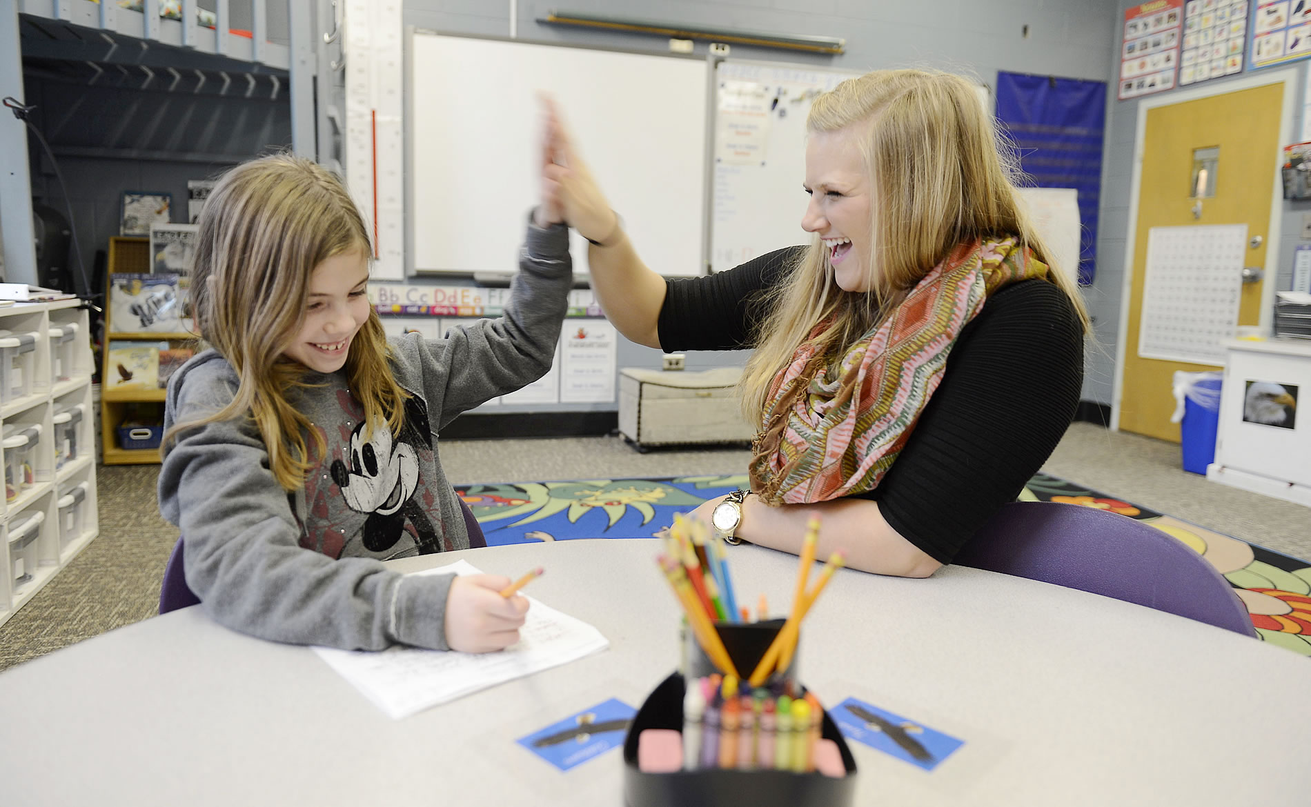 Student high-fiving a young kid