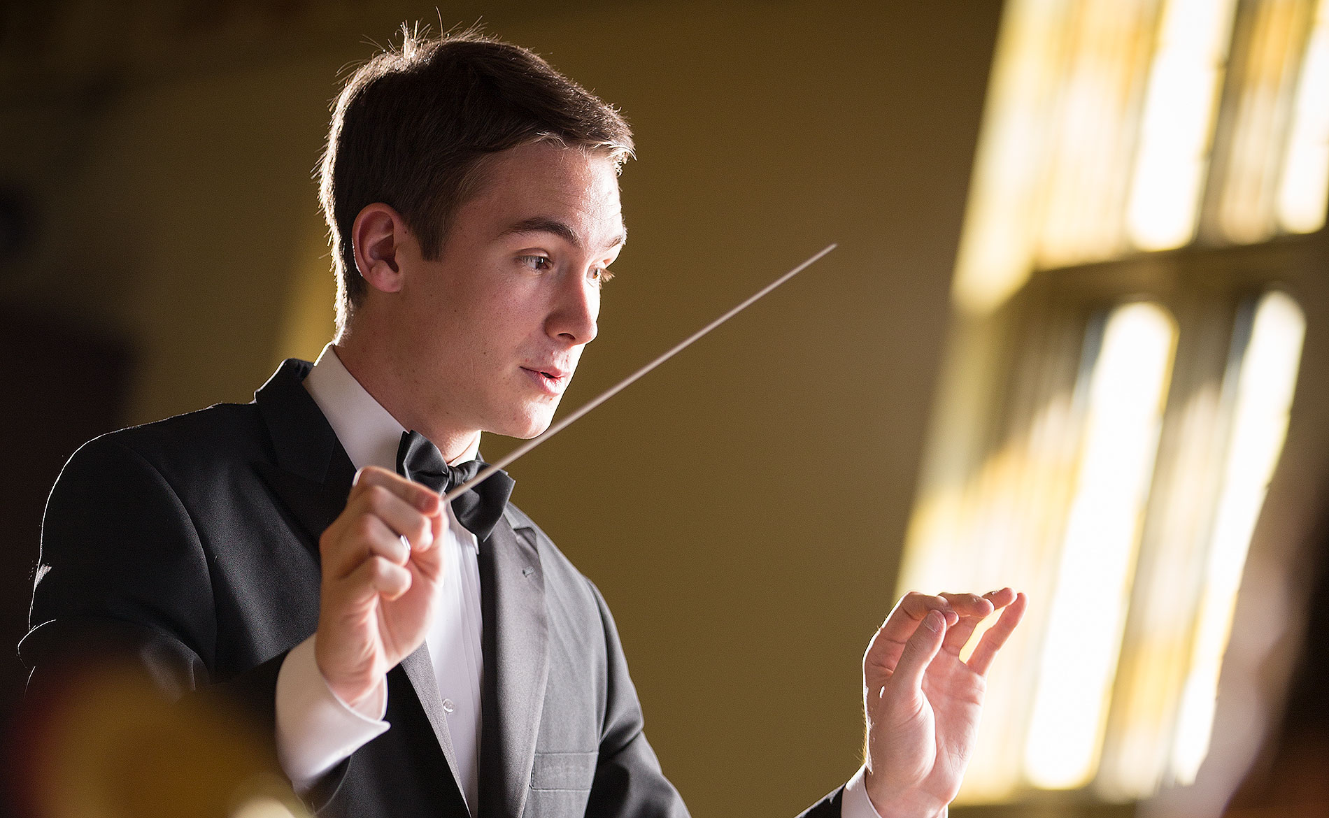 A student conducting music