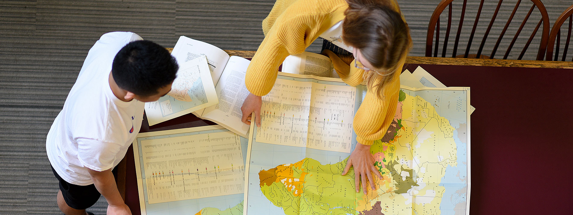 Students study maps at the library