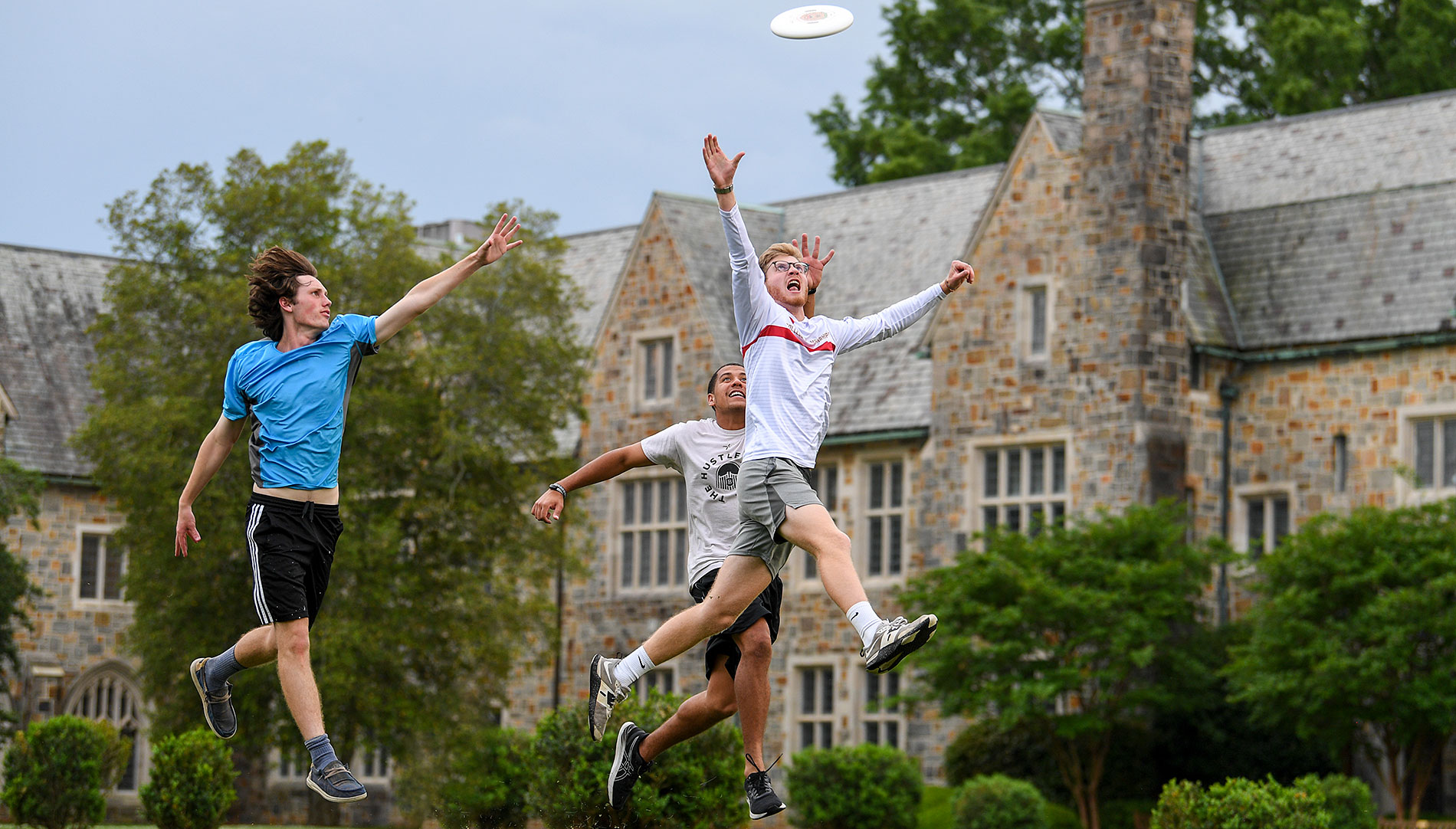Male students jumping for a frisbee