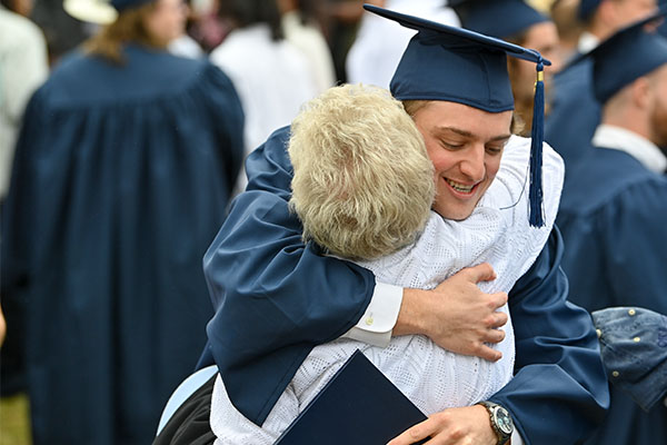 male graduate hugging parent
