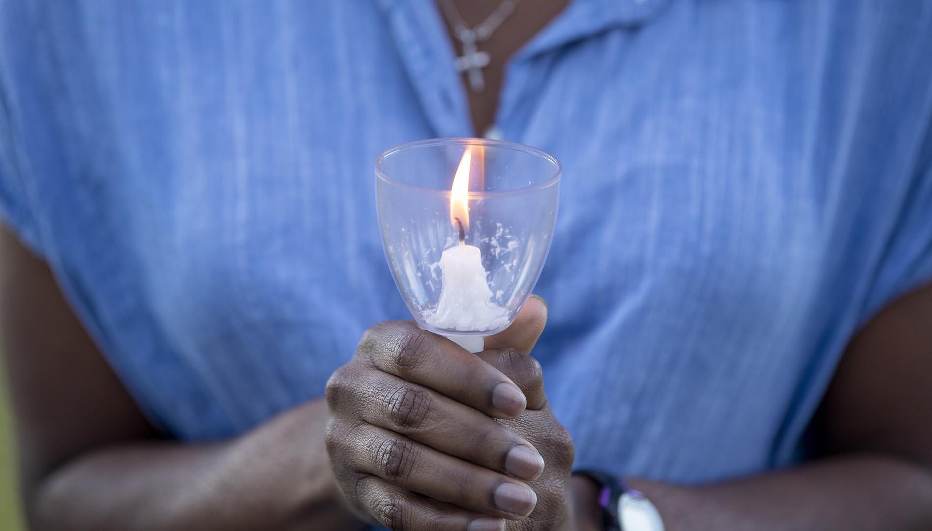 Student holding a lit candle for vigil