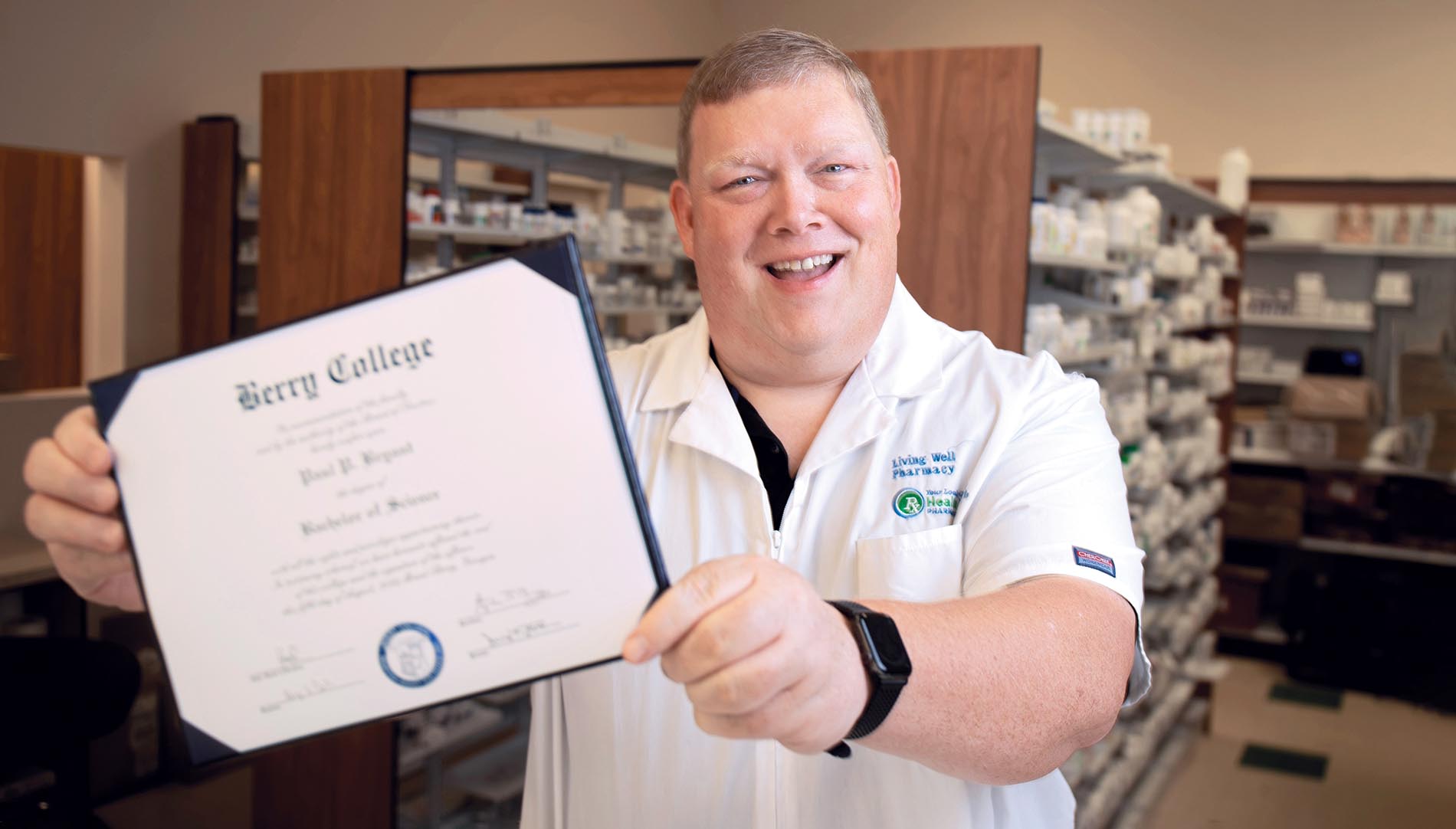 Paul Bryant holding diploma in a pharmacy