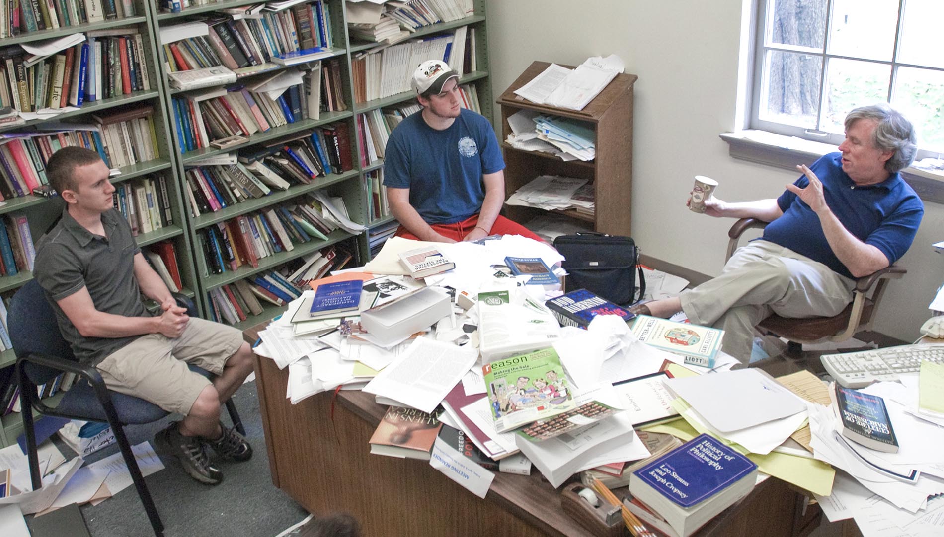 Peter Lawler in his office with students