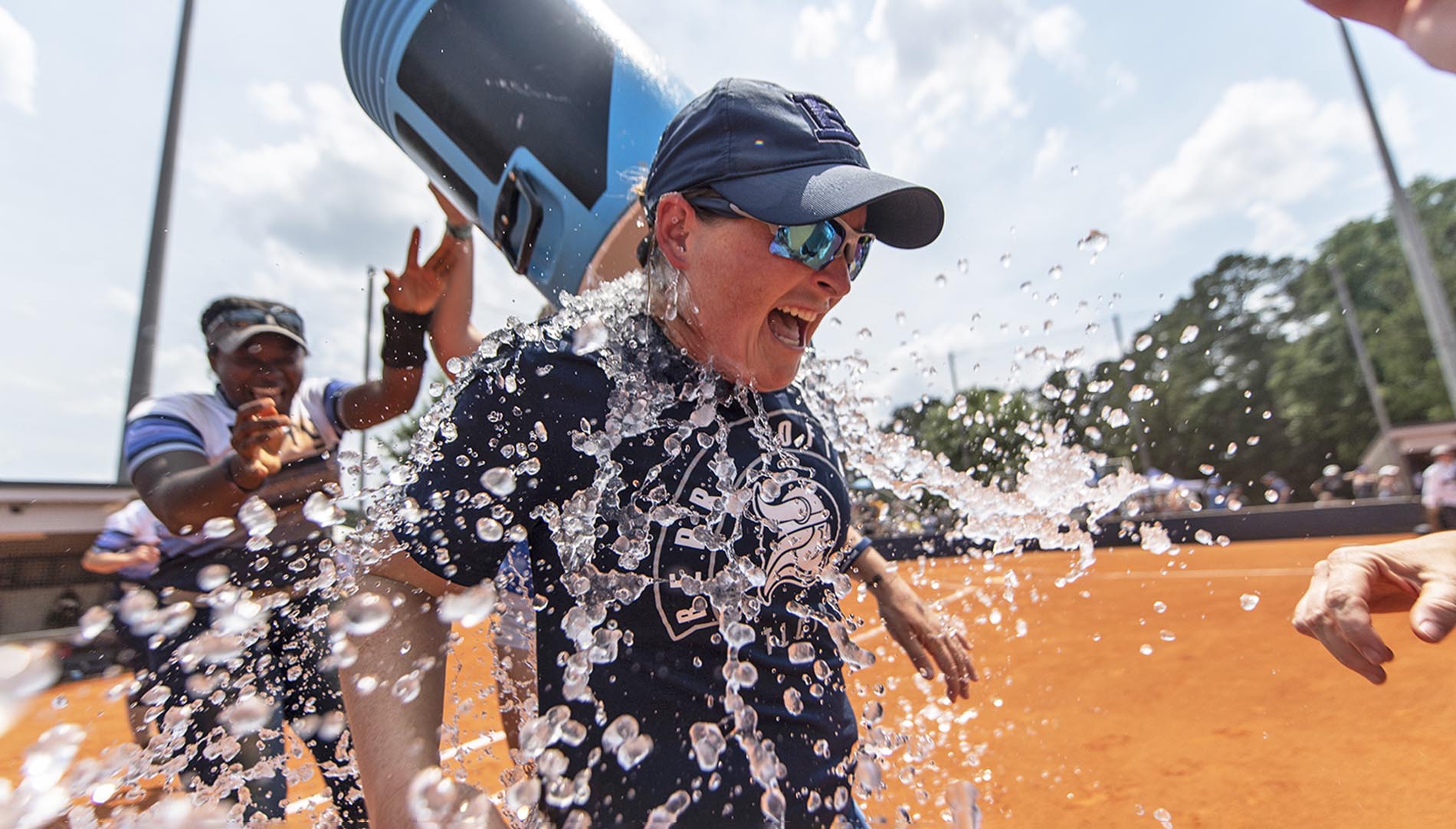 Softball players dumping water on coach