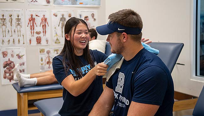 Student athletic trainer Jamie Jang works with an athlete.