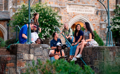 diverse group of students laughing on stone steps