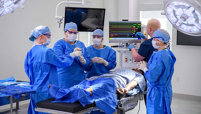 Group of students in a mock surgery room preparing for a surgery