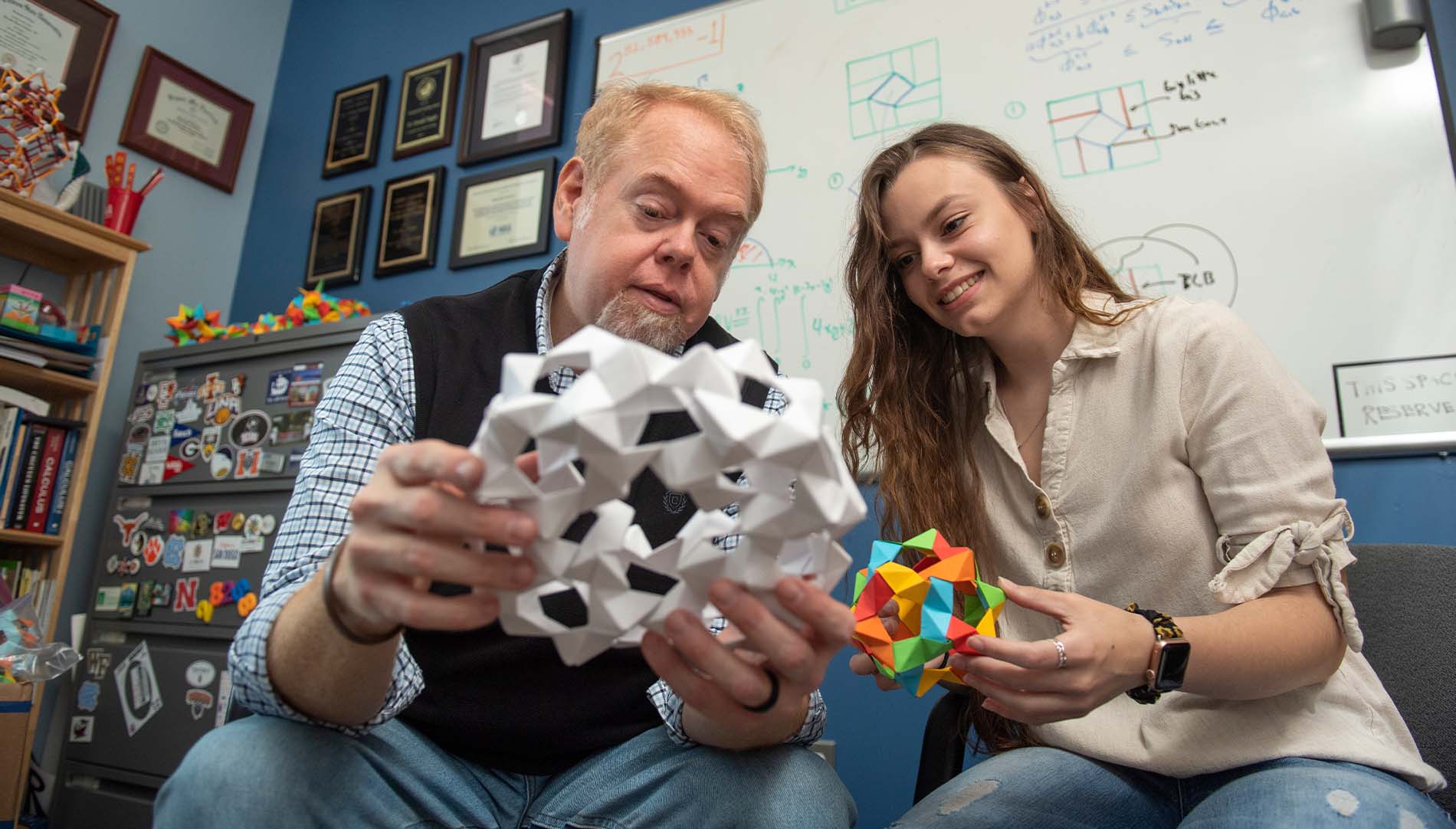 Ron Taylor and student working on origami projects