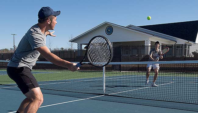 Two students playing tennis at the Rome Tennis Center at Berry College