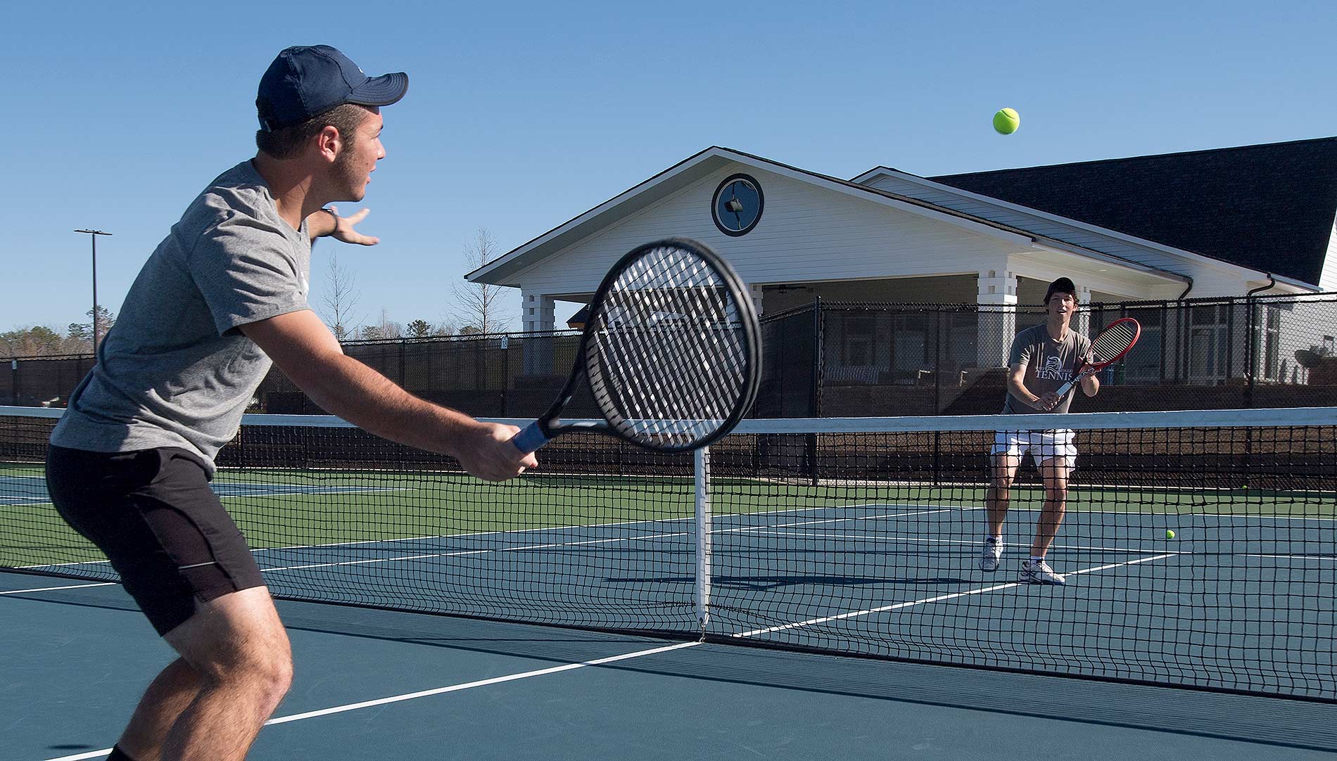 Two students playing tennis at the Rome Tennis Center at Berry College