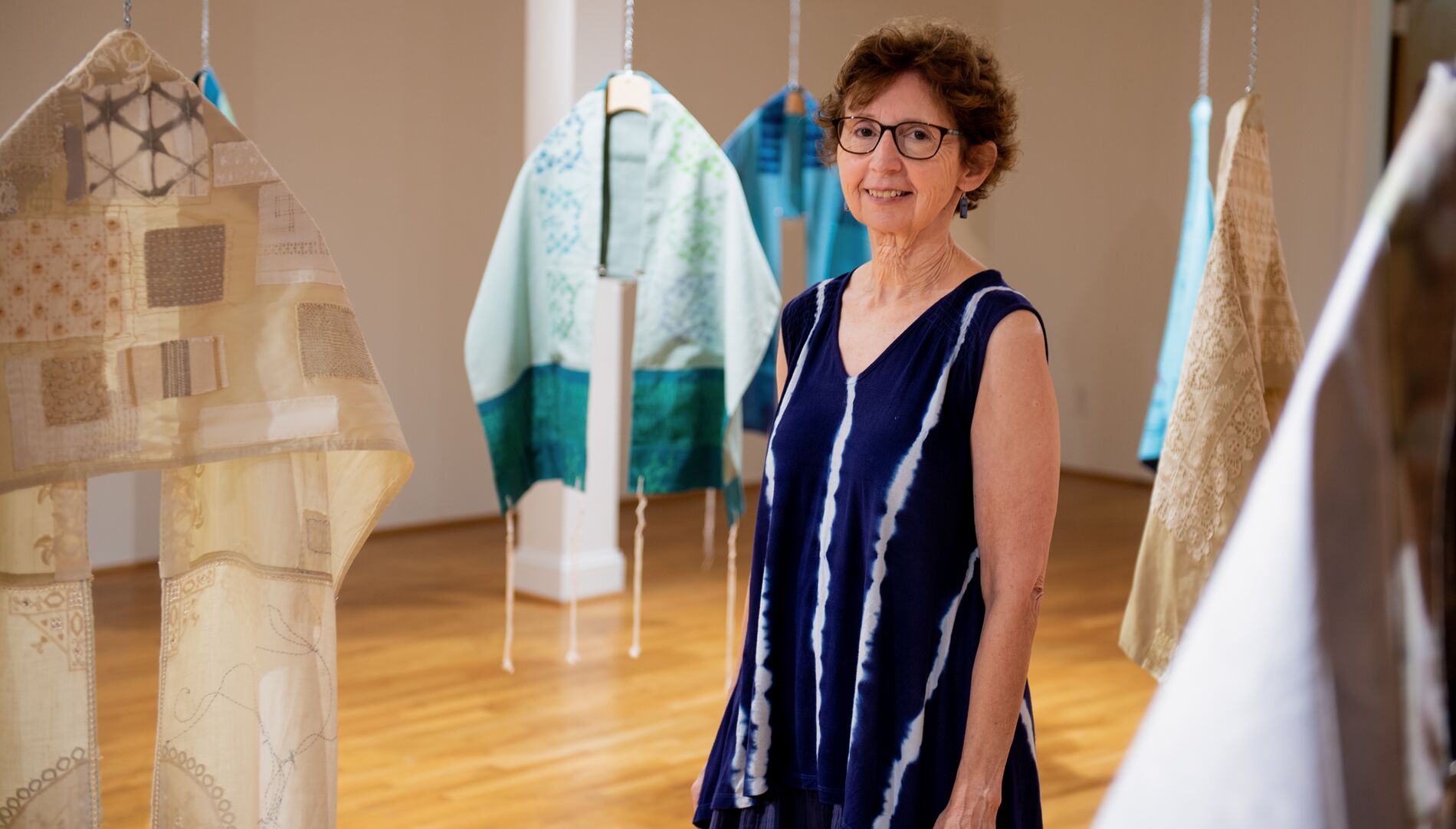 Woman in front of scarves