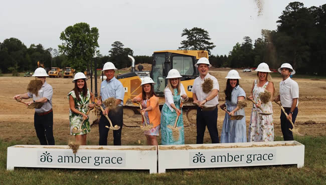 group of people shovel dirt for groundbreaking