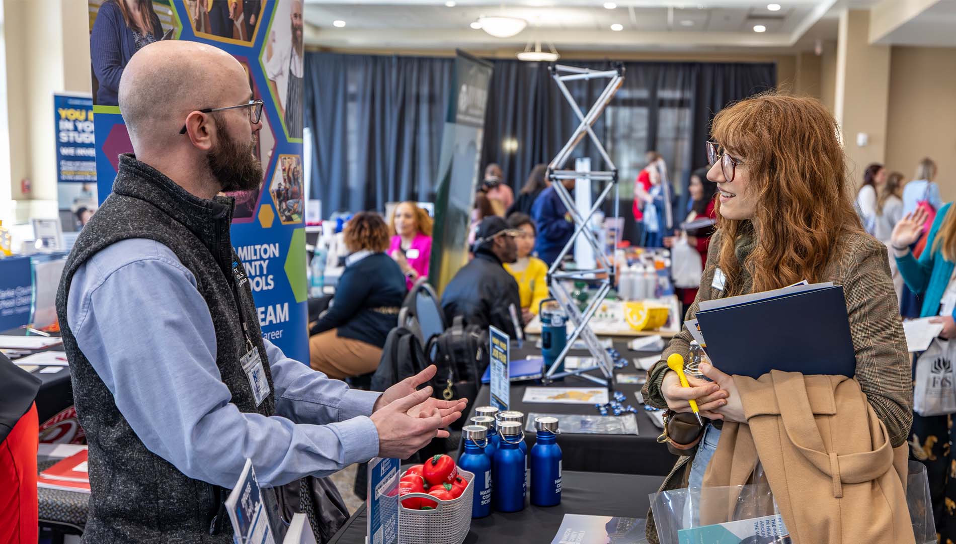 A female student talking with a male professional during a career fair