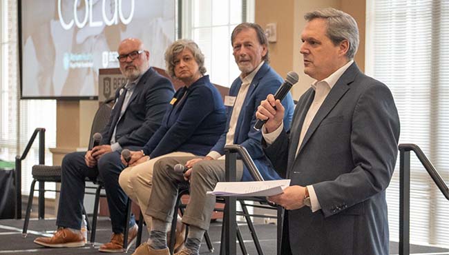 Panel of four experts speaking on a stage