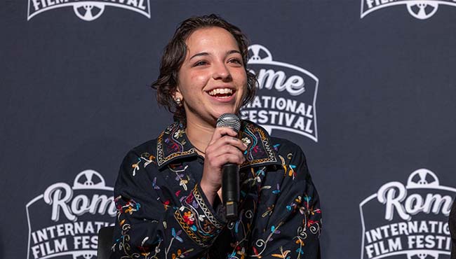 student speaking into mic in front of RIFF banner