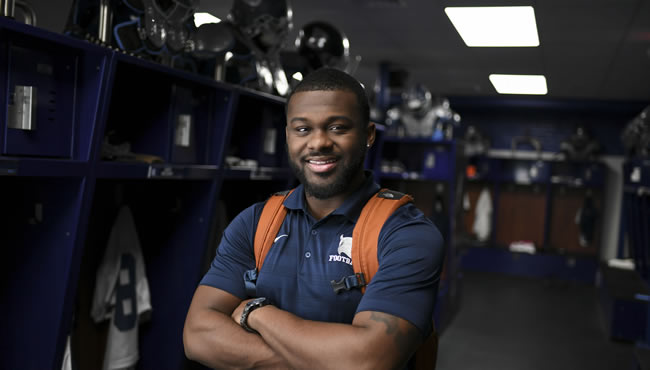 Justen Booket smiling in a locker room