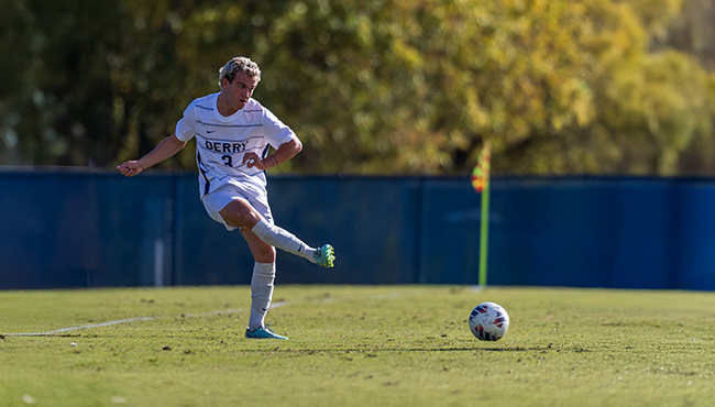 Alex Forrand kicking a soccer ball on a field