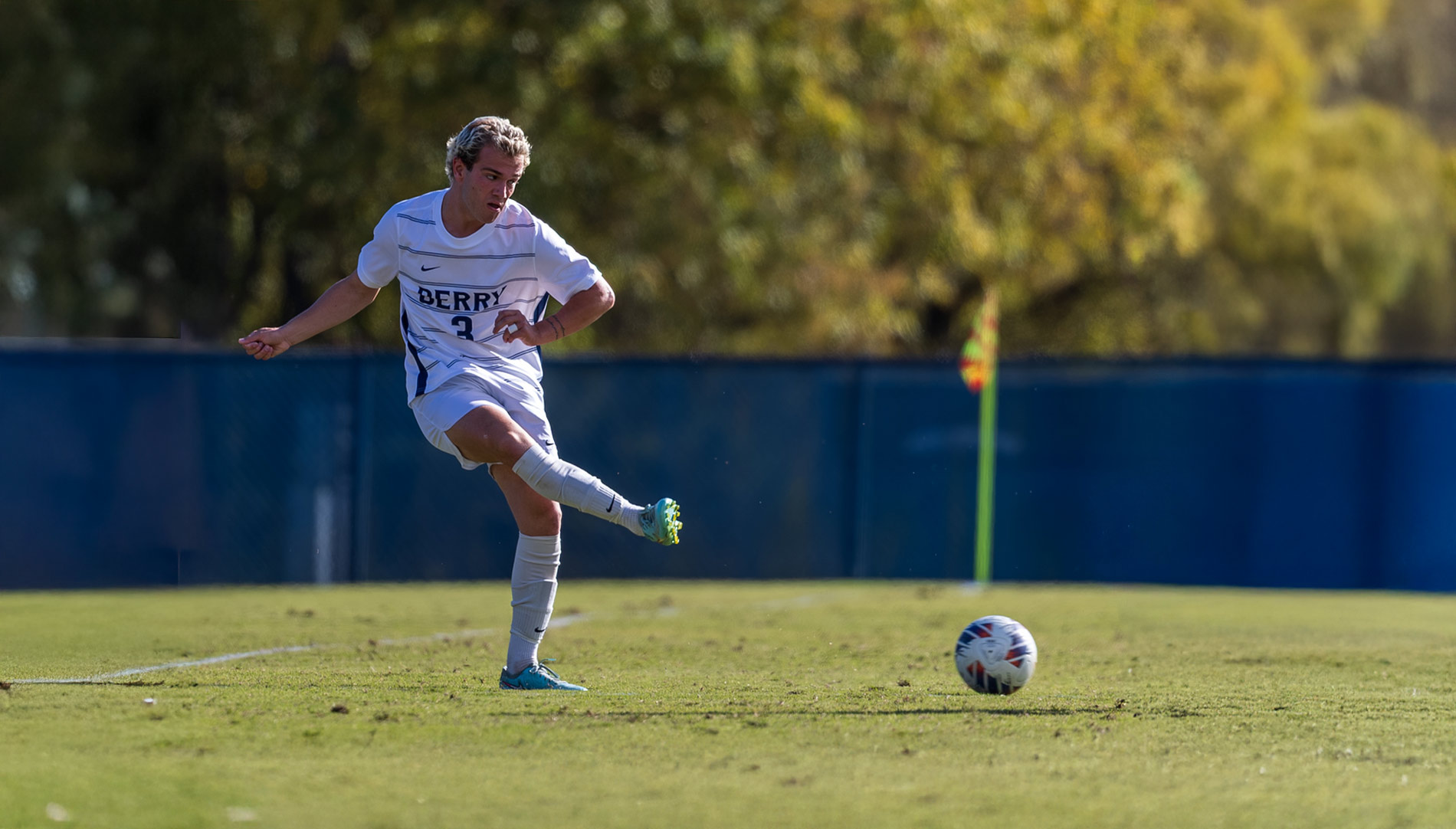 Alex Forrand kicking a soccer ball on a field