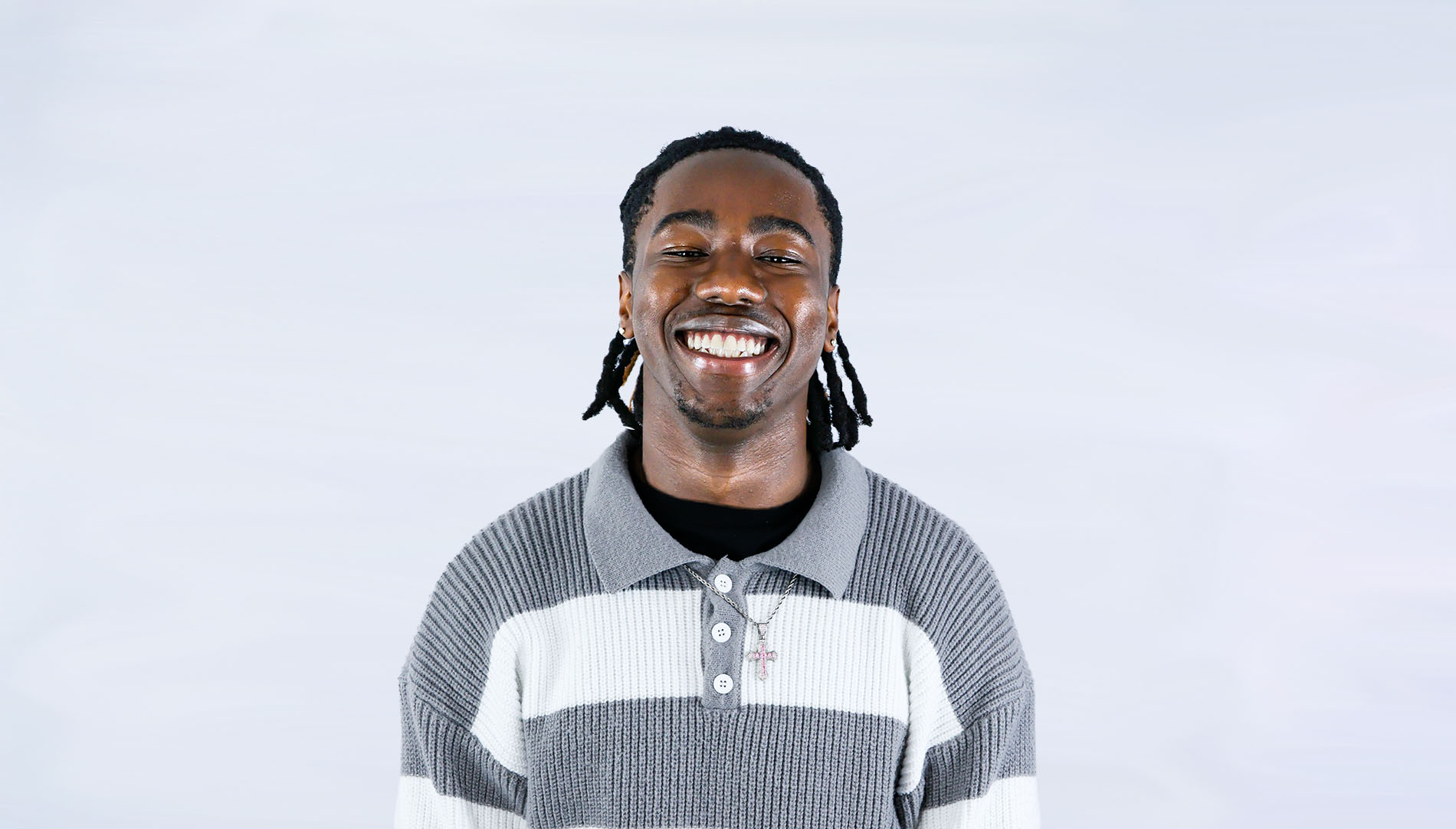 Nile King smiling in front of a light gray background