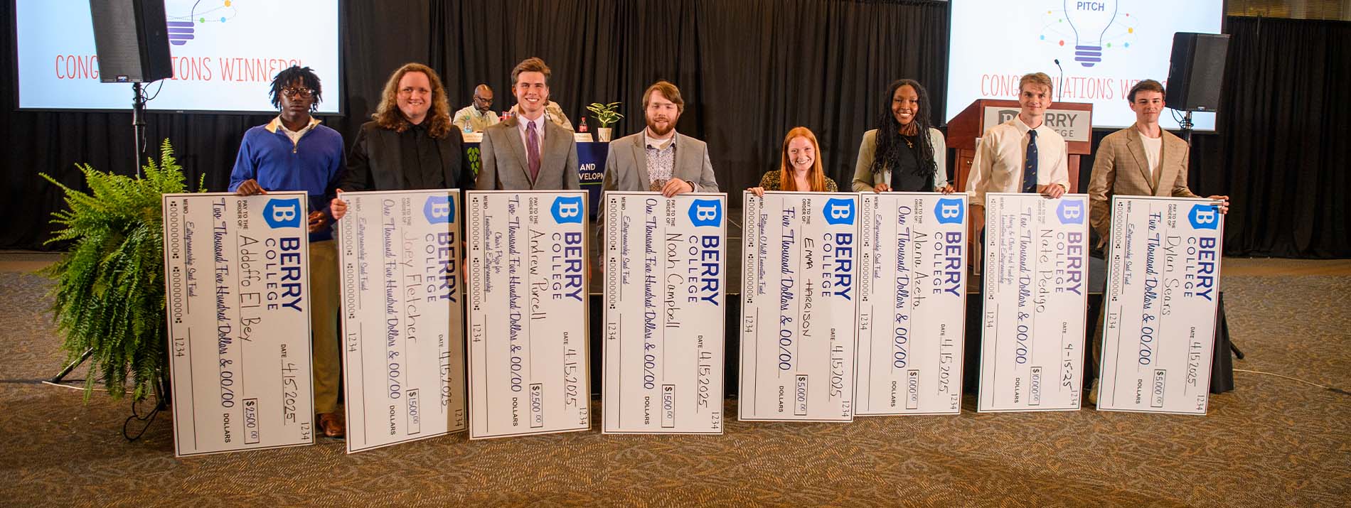 Group of Berry College students smiling with oversized checks