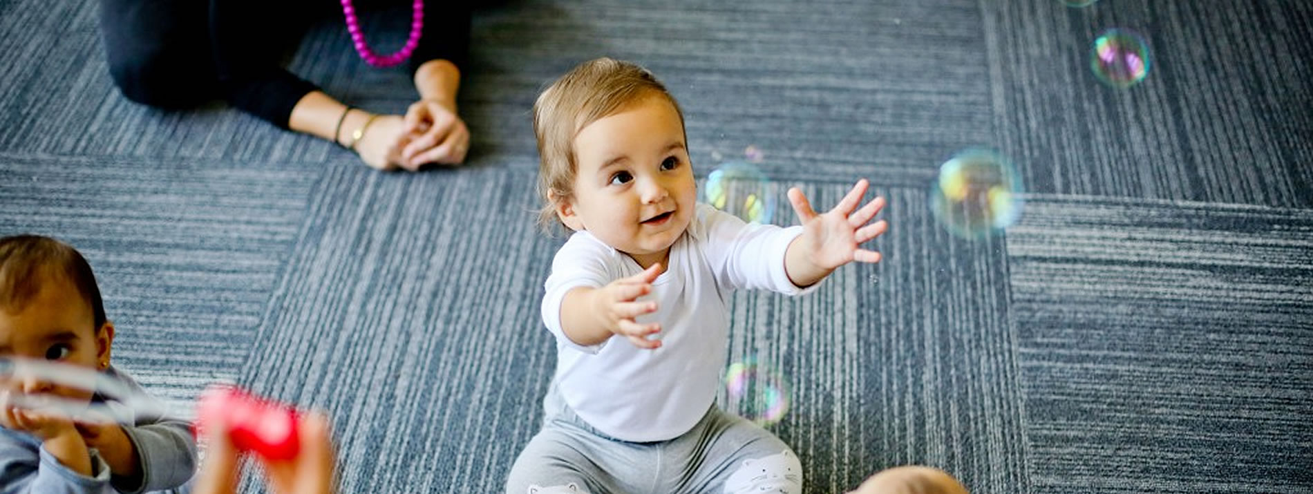 two babies playing with bubbles
