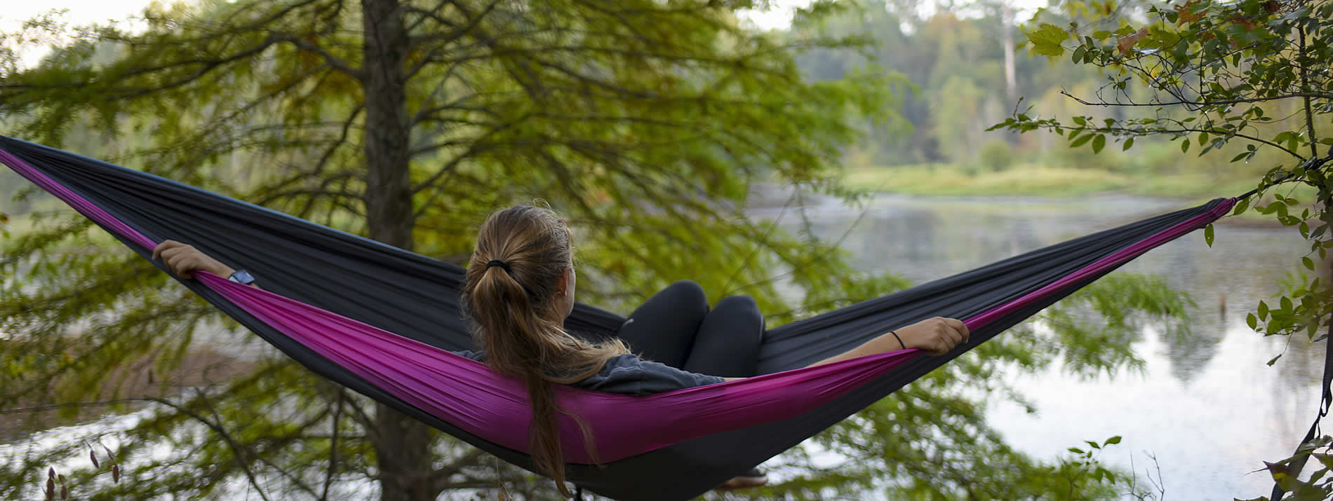 student laying in a hammock at the reservoir