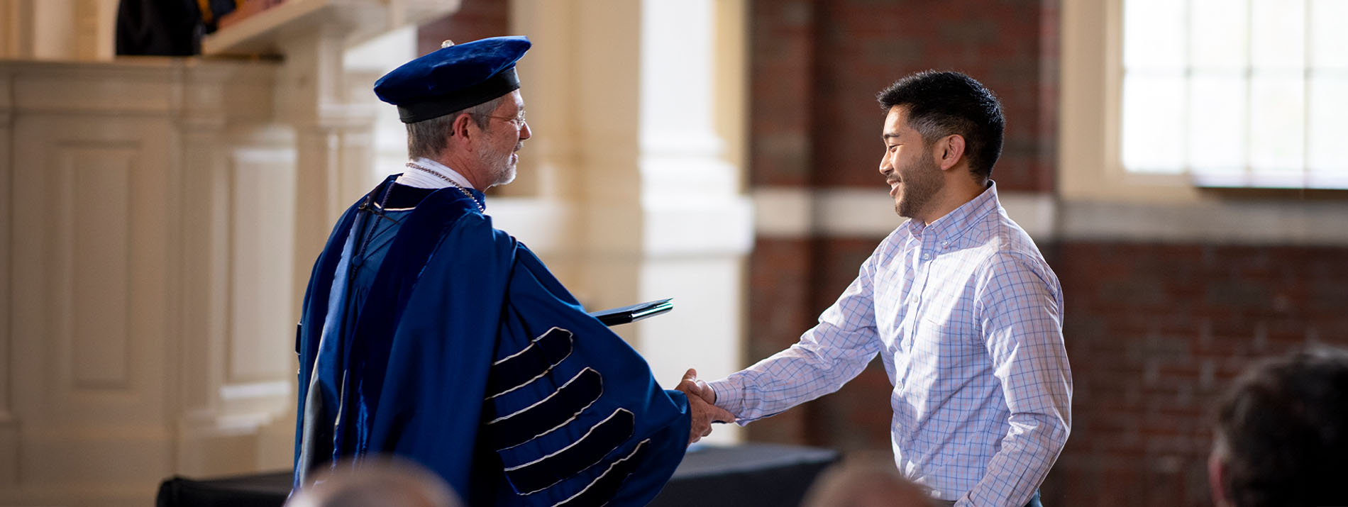 Former Berry College president shaking hands with award recipient