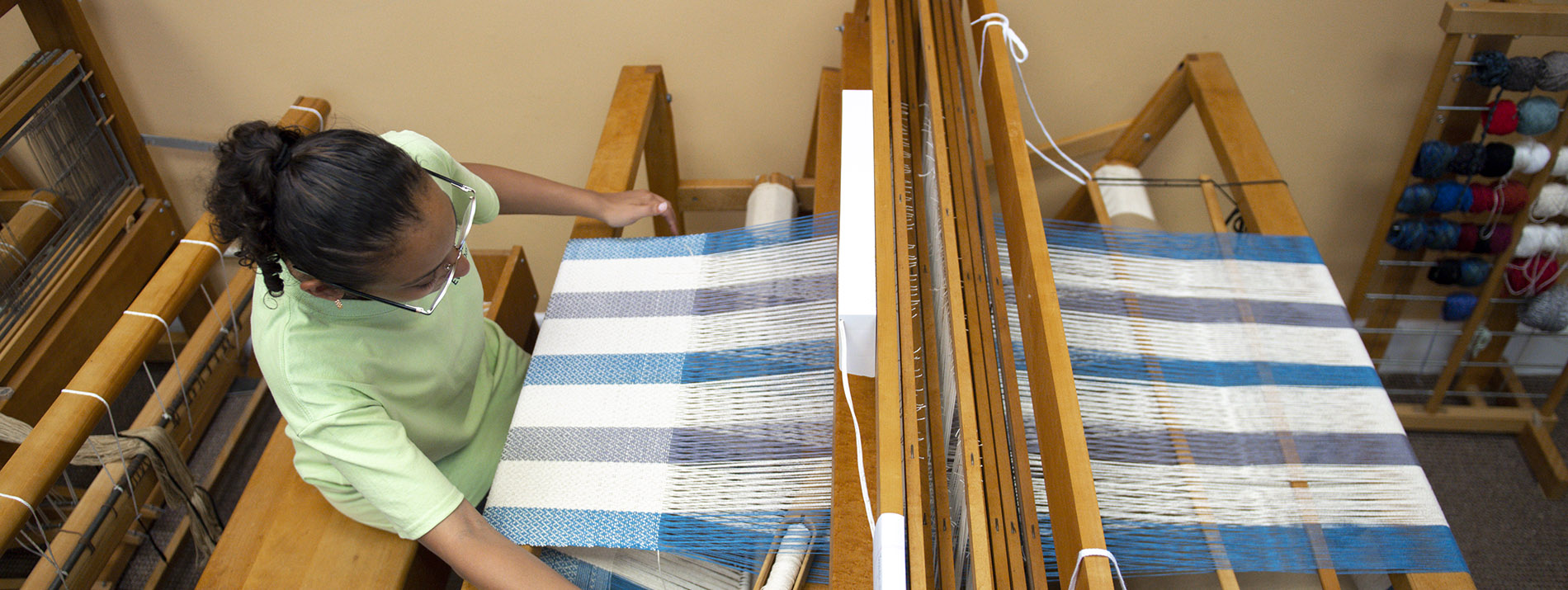 female student sitting at a loom